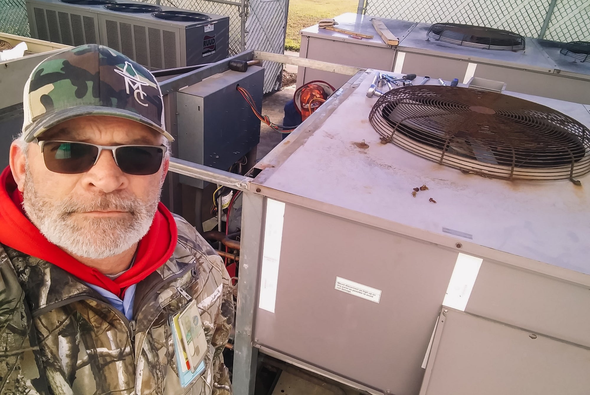 Elan Melvin is standing next to an air conditioning unit.